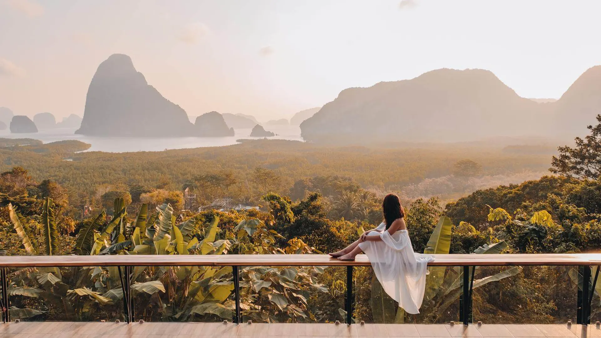 Frau in Weiß auf einer Panorama-Terrasse über der Phang-Nga-Bucht in Thailand im goldenen Abendlicht